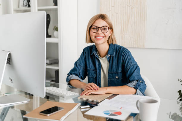 istock Happy young female freelancer working on the computer looking at camera. 2076346196