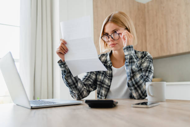 istock Stressed young female paying domestic bills, having problems with billing overdue at home kitchen 2076363112