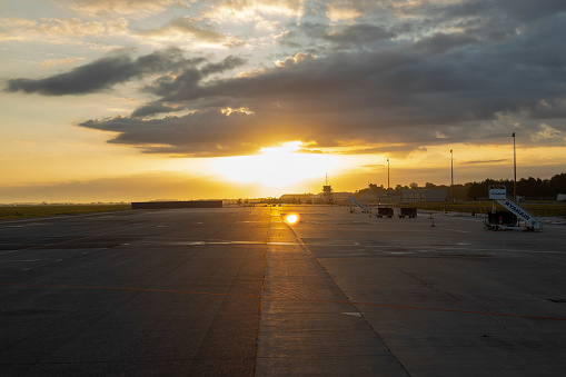 Sunrise and dark clouds in the morning at an empty Modlin airport - air traffic control tower - stairs to the Ryanair plane