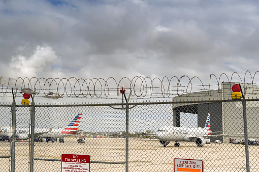 Miami, Florida, USA - 27 January 2024: Coils of razor wire on the perimeter fence of Miami International airport