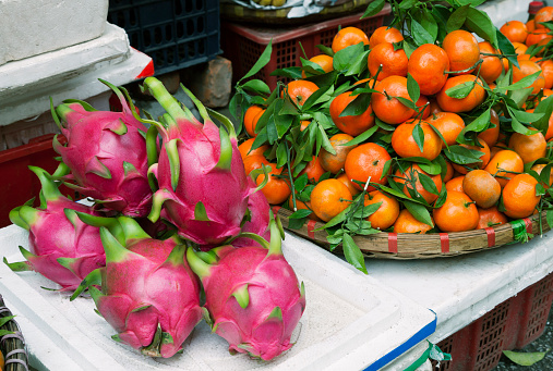 Dragon fruits and tangerines at a market in Hanoi, Vietnam