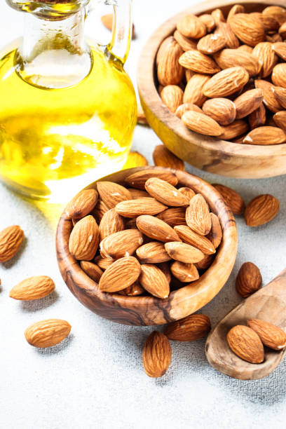 istock Almond nuts in wooden bowl at white background. 2076511069
