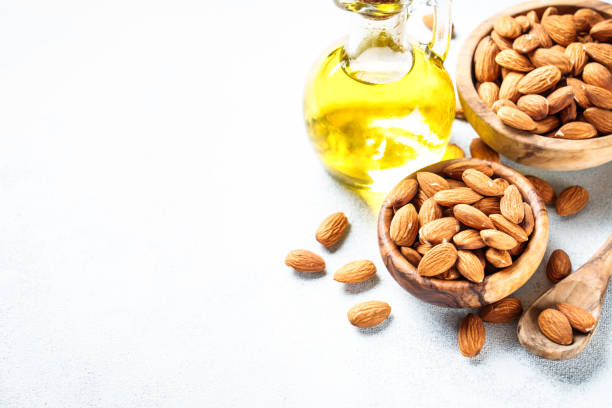 istock Almond nuts in wooden bowl at white background. 2076511073