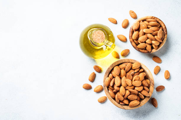 istock Almond nuts in wooden bowl at white background. 2076511583