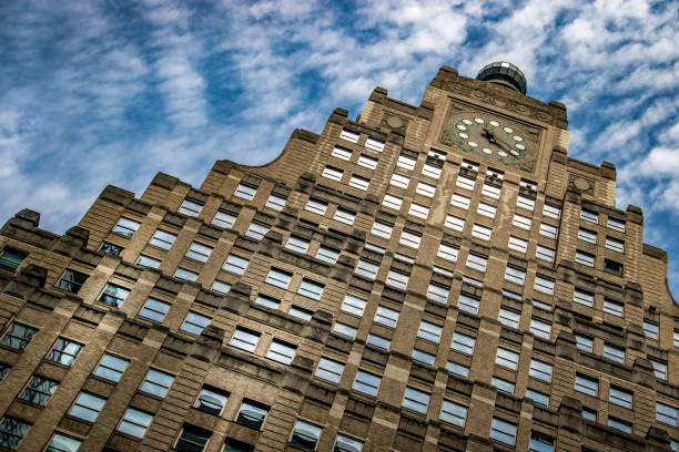 The Paramount Building in New York City, located at 1501 Broadway in Times Square, is a historic Art Deco skyscraper that has been a prominent feature of the city's skyline since its completion in 1926. \n\nDesigned by architect Thomas W. Lamb, the Paramount Building originally served as the headquarters for the Paramount Pictures film studio. Known for its intricate terra-cotta facade, impressive setbacks, and a distinctive clock tower, the building stands as a testament to the opulence and architectural innovation of the Roaring Twenties. \n\nToday, while the studios are gone, the Paramount Building endures as a cherished example of Art Deco design, contributing to the vibrant energy of Times Square.