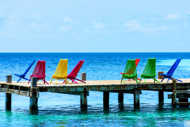 Multicolored Adirondack Chairs on a Boat Dock overlooking the Ocean, Belize, Caribbean
