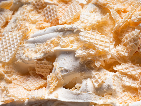Frozen Creamy flavour gelato (called Russian Ice Cream) - full frame detail. Close up of a white surface texture of Ice cream covered with pieces of broken waffle.