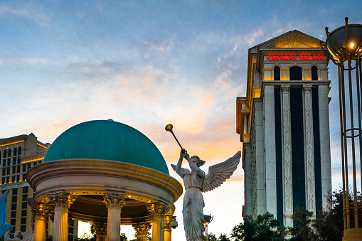 Las Vegas, Nevada - USA: Caesars Palace at dusk with angel sculpture blowing trumpet against colorful sky