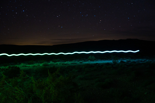 Long exposure colored light trails over the desert floor in death valley national park.