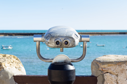 A binoculars on a lookout over La Caleta beach in Cadiz.