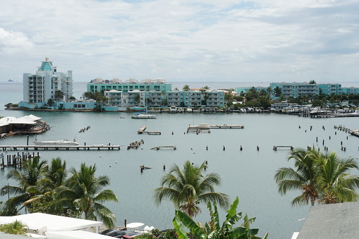 Philipsburg, Sint Maarten, 02 22 2024: Hotels and apartments of tourist resorts with private yachts in Oyster Bay near Philipsburg town situated in Caribbean Island, Sint Maarten observed from the hill surrounded by palm trees.