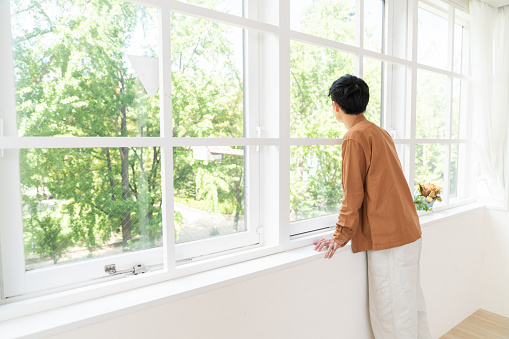portrait of asian young man,back view,window