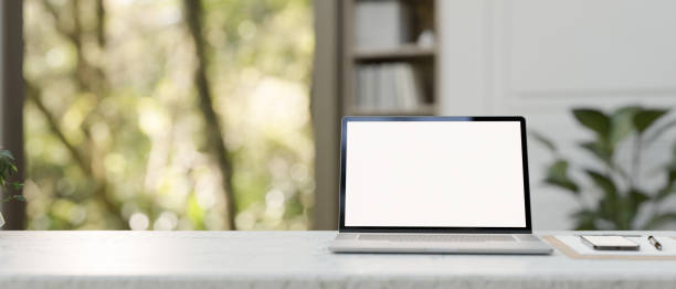 istock A white-screen laptop mockup, a clipboard paper, and a smartphone on a table in a modern office. 2077014559