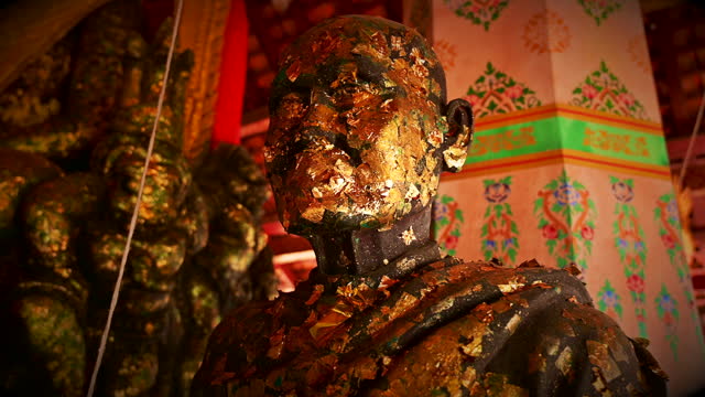 Ancient Buddha statue that is revered and decorated with gold leaf in Nakhon Sawan Province