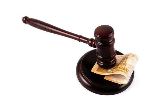 Judge's gavel and 100 Russian ruble banknote on a white background
