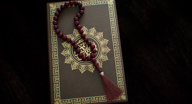 Rosary beads made of wood placed upon a sacred book