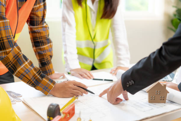 istock Engineers or inspector holding blueprint of construction on site. Contractor inspection drawing before start project civil. Prepare construction project planning, consulting, architecture. 2077173407