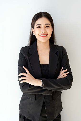 Portrait of  business woman with arms crossed looking at camera. Happy smiling mid businesswoman standing in office.