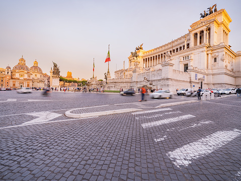 The Piazza Venezia in Rome exudes evening charm, with the warm glow of sunset accentuating the historic architecture.