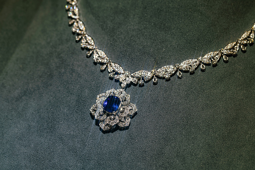 Golden necklace with Aquamarine gemstone isolated on grey.