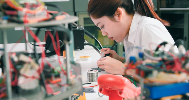 istock Asian Female Technician Soldering Electronic Parts in Lab 2077222637