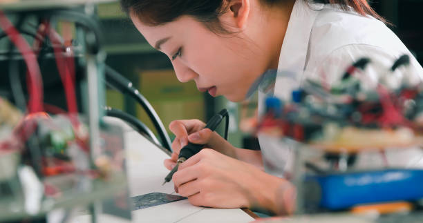 istock Asian Female Technician Soldering Electronic Parts in Lab 2077222638