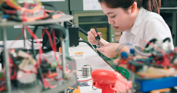 istock Asian Female Technician Soldering Electronic Parts in Lab 2077222654