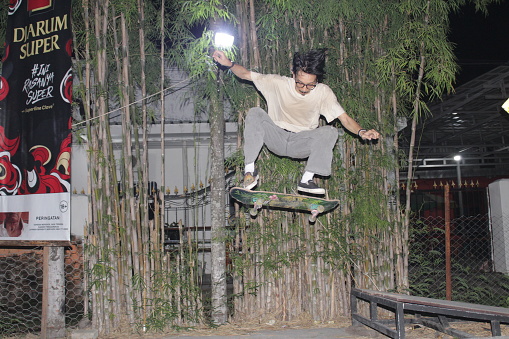 Indonesia - Medan 01 August 2023
an asian man doing skateboard tricks on a ramp