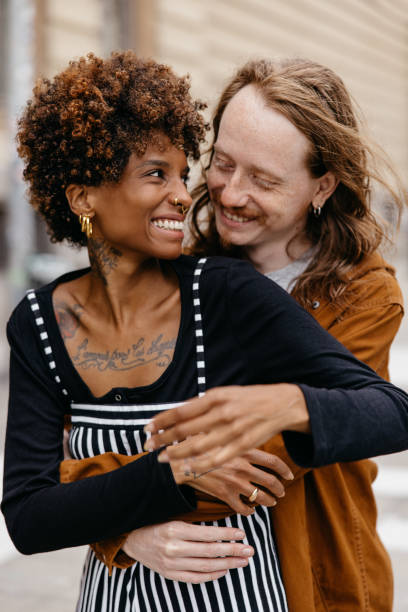 istock Embracing couple sharing a joyful moment on city streets 2077285706
