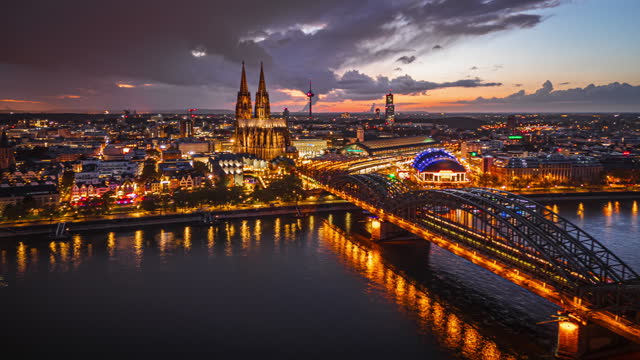 4K Aerial view Hyper lapse Footage of Cologne cathedral over Hohenzollern Bridge though cologne central station and musical dome at sunset time in Downtown of Cologne, Germany