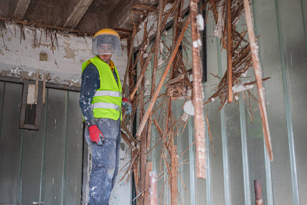 A construction worker is renovating an apartment, demolishing the old one
