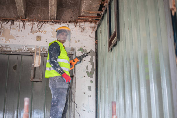 Renovation concept, construction worker demolishing ceiling in apartment