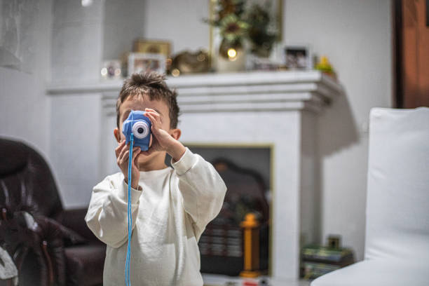 Asian playful Japanese boy Looking At Camera At Home.Boy Playing Camera Toy.