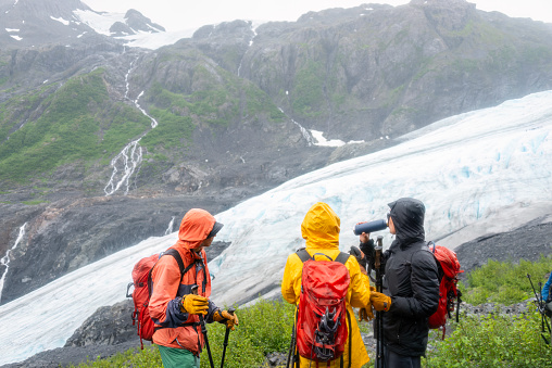 People carrying ice crampons, hiking Exit Glacier track in the snow. Kenai Fjords National Park. Alaska.