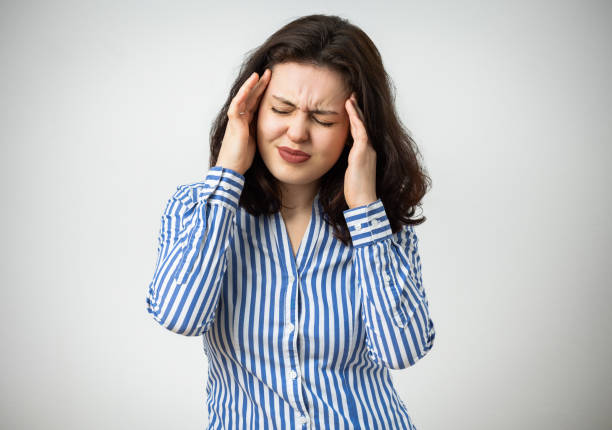 istock Young beautiful woman has headache isolated studio portrait 2077411922