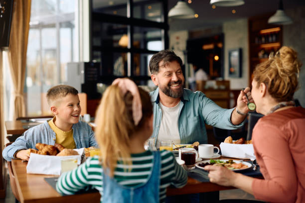 istock Happy family having fun while eating breakfast in a hotel. 2077443312