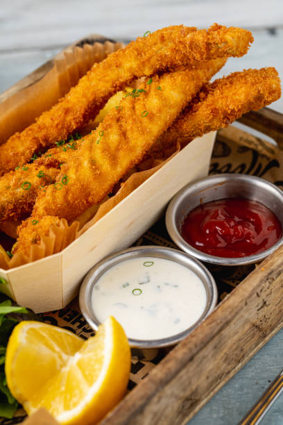 istock Fish and chips with fresh greens and sauces on wooden table 2077477830