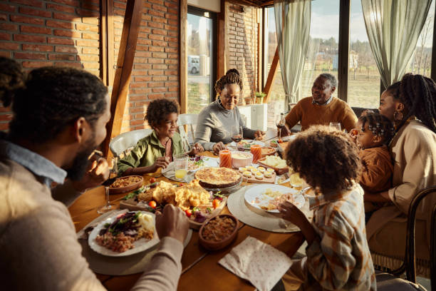 Black multi-generation family having a meal at dining table.
