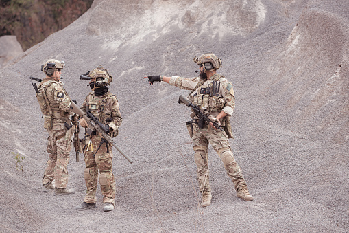 Soldiers in camouflage military uniforms carrying weapons, Reconnaissance missions in rugged mountains, Assault infantry battle training.