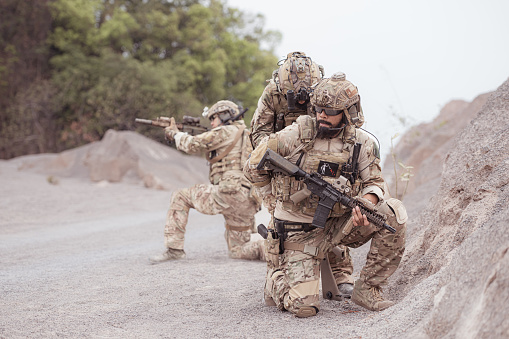 Soldiers in camouflage military uniforms carrying weapons, Reconnaissance missions in rugged mountains, Assault infantry battle training.