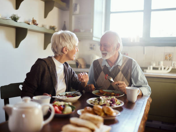 istock Happy senior couple having lunch in the kitchen. 2077515934