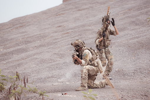 Soldiers in camouflage military uniforms carrying weapons, Reconnaissance missions in rugged mountains, Assault infantry battle training.