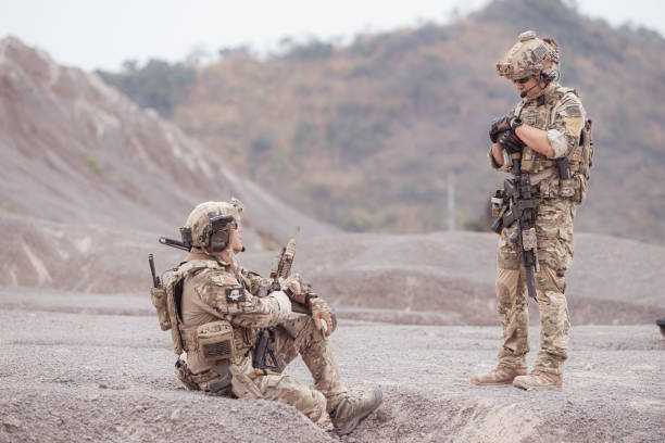 istock Soldiers in camouflage military uniforms carrying weapons 2077538157