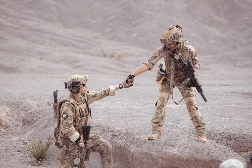 Soldiers in camouflage military uniforms carrying weapons, Reconnaissance missions in rugged mountains, Assault infantry battle training.