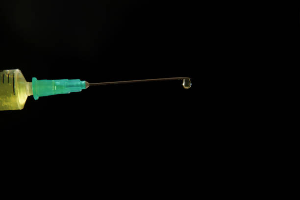Plastic medical syringe icon with needle isolated on blue background.