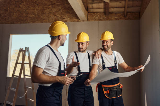 istock Team of manual workers talking about blueprints at construction site. 2077547761