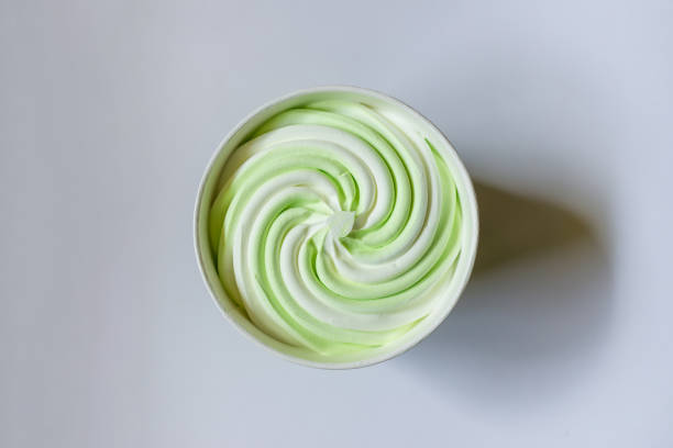 Ice cream in the paper cup on a white,gray background, top view.soft focus whipped ice cream standing on a paper background.Copy space.
