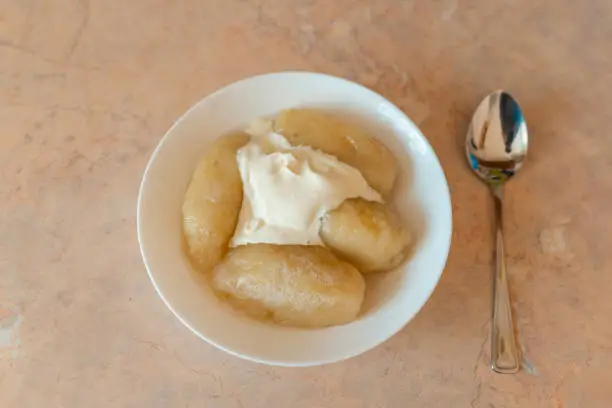 Photo of Traditional Lithuanian dish meal cuisine, stuffed meat potato dumpling,most popular Lithuanian national dish on a plate near spoon.