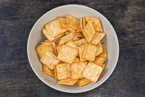 istock Salty crackers in bowl on a black surface, top view 2077625499