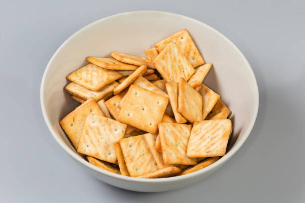 istock Salty crackers with onion addition in bowl on gray background 2077625511